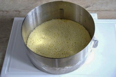 Put the cut out biscuit in a pastry ring (diameter 18 cm), the bottom of which is tightened with cling film, place the ring on a hard surface.