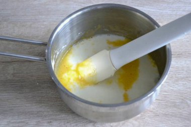 Pour milk into the prepared mixture, heat over low heat with constant stirring until the very beginning of boiling, as soon as the mass begins to thicken, quickly remove from heat so that the yolks do not curdle.