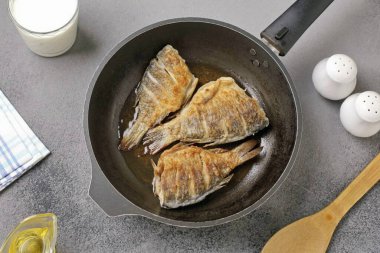 Heat vegetable oil in a frying pan and fry the fish on both sides until golden brown.