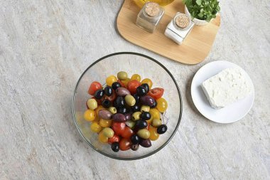 Add cherry tomatoes, large can be cut in half, small whole. Lay out the assorted olives.