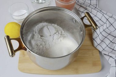 Derin ve rahat bir tava al. Bir bardak nişasta ve 1,5 bardak şeker dök. Karıştır.