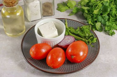 Domates peyniri ve fesleğenli salata hazırlamak için gerekli tüm malzemeleri hazırlayın. Peynirin tadına bak. Peynir çok tuzluysa, o zaman tabağa tuz eklemeyin..