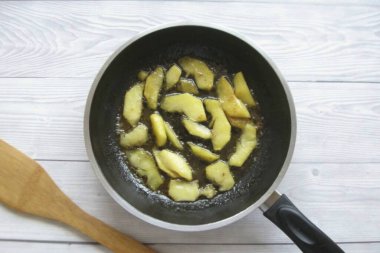 Şeker tamamen çözülüp hafif kahverengi bir renk elde edilene kadar elmaları kaynatmaya devam edin. Sizi uyarmak isterim ki tüm şeker çeşitleri bu rengi vermez..