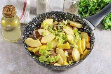 Elmaları ya da elmaları suyla çalkala, parçalara ayır ve tohum bloklarını kes. Dilimlere ayırın. Kereviz sapını parçalara ayır ve elma dilimleriyle birlikte tavaya ekle..