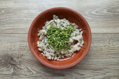 Yeşillikleri ince ince doğra ve kıyma balığıyla kaseye ekle..