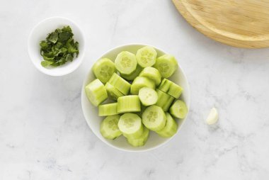 Sebze soyuculu salatalık soy. Nane şekerini ince ince doğra. Sarımsağı soy..