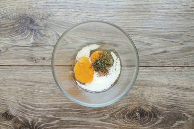 Yumurtaları bir kaseye kır, sütü koy ve otları ekle. Her şeyi çatalla karıştır, pürüzsüz olana kadar..