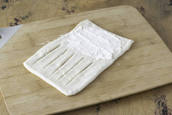 Сделайте разрезы на одной половине треугольника, но не доходите до конца. Посыпать второй край крахмалом.