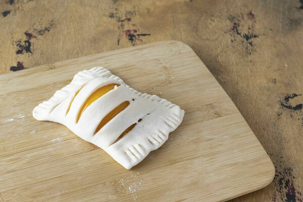 Сложите тесто пополам, ущипните края вилкой.