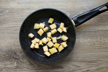 Kabak kabağını kabuk ve tohumlardan soyup parçalara ayırın. Kızartma tavasına sebze yağı dök ve orta sıcaklıkta ısıt. Kabağı tavaya ekle ve her şeyi 5 dakika sotele koy.
