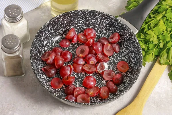 Rinse the grapes in water, cut each berry in half. If there are bones in it, then remove them. Place the slices in a non-stick pan and simmer lightly, about 2-3 minutes.