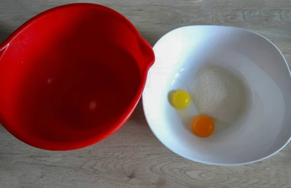 Divide 2 eggs into whites and yolks. Add 70 grams of sugar to the yolks, grind until white. Add a pinch of salt to the yolks, beat in a fluffy foam.