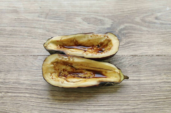 Разрежьте баклажаны вдоль на две половинки, удалите часть внутри половинки и смажьте их соевым соусом.