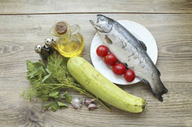 Trout 'u fırında kabakla pişirmek için gerekli tüm malzemeleri hazırlayın. Yıka, kurut, sebze ve otlar. Alabalığın pullarını, solungaçlarını ve bağırsaklarını çıkarın. Alabalığı durula ve kurut..