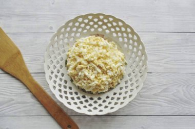 Sert haşlanmış yumurta, soğuk ve soyulmuş. Öğütücüye rendele ve dikkatli bir şekilde elma katmanına yerleştir..