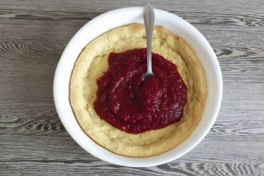 Yaban mersini dolgusunu bitmiş sıcak kekin üzerine koy. Dağıt.