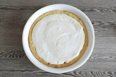 Dolgunun üzerine kırbaçlanmış sincap koyun. Sakin ol. Pastayı 10 dakika boyunca 180 derecede ısıtmalı fırına koy..