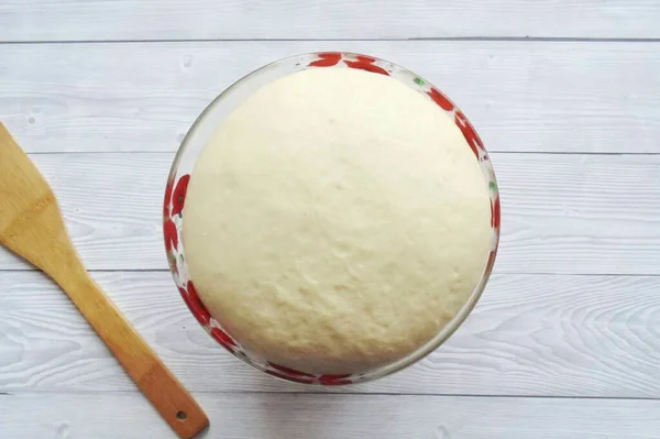 Cover the bowl of dough with cling film and place in a warm place. After an hour and a half, it will increase significantly in volume.