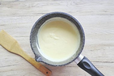 Tenceredeki süt kaynamaya başladığında yumurta sarısı ve şeker karışımını içine dökün. Krema kalınlaşana kadar sürekli karıştır..