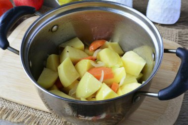 Bir tencereye sebze yağı dök, patates, soğan ve havuç ekle. 5-6 dakika boyunca sebze kızartmak, karıştırmak, küçük bir ateş yakmak..