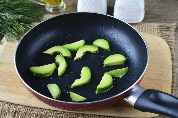 Pour a little oil into the pan, heat up and lay out the avocado slices. Fry for 10-15 seconds.