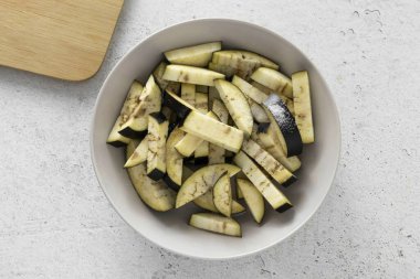 Patlıcanı yıka, küp küp doğra. Tuz, her şeyi karıştır ve 20-30 dakikalığına ayrıl. Sonra patlıcanı soğuk suda durula ve sık..