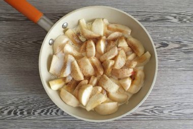 Tereyağını kızartma tavasında erit. Üzerine elma dilimleri koy. Şeker ve tarçın ekle. Karıştır. Ateşe verin. Fry, ara sıra karıştırıyorsun. İlk başta, bir sürü meyve suyu göze çarpar, buharlaşana ve şeker karamelize olmaya başlayana kadar beklemelisiniz. Bu polisten.