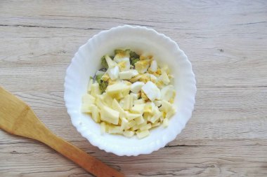 Yumurtaları kaynatın. Güzel, soyun ve güzelce doğra. Elmayı soy ve küçük küplere böl. Salata kasesine yumurta ve elma ekle..