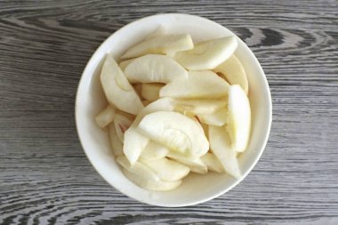 Elmaları soy, tohum kutusunu çıkar. İnce dilimler halinde kes. Limon suyu serpin.