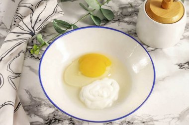 Ekşi kremanın ikinci kısmını yumurtayla çırp..