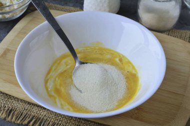 İrmik dök. Karışımı karıştır ve bırak 15 dakika irmiği şişirmek için.