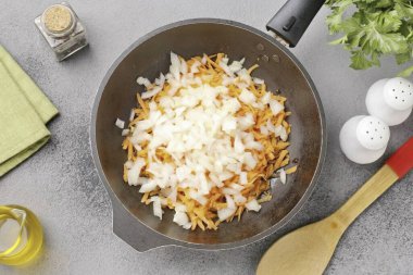 Paralel olarak, yağı bir tavada ısıt ve doğranmış soğanı ve rendelenmiş havucu koy. Yumuşayana kadar sote sebze.