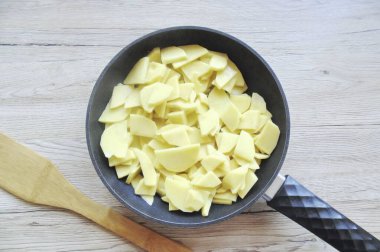 Patatesleri soy, yıka ve dilimle. Soğana sarımsak ve biraz tuz ekle..