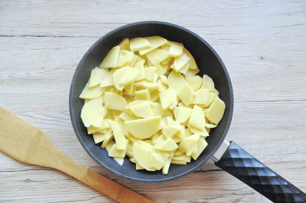 Patatesleri soy, yıka ve dilimle. Soğana sarımsak ve biraz tuz ekle..