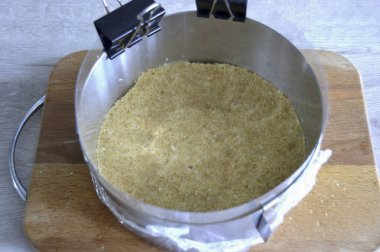 Pastayı monte etmek için bir form hazırlayın. Çapı 18 cm olan sökülebilir bir yüzük. Ringin altını streç filmle sıkıştır, sert bir yüzeye yerleştir. Kenarına asetat bir bant yerleştirmek arzulanır. Kırıntıları tereyağlı, Compac