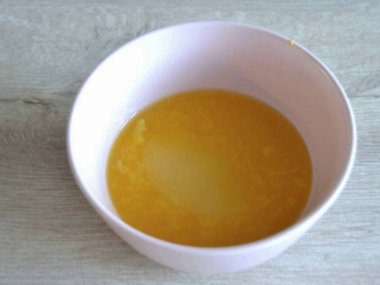 Sıkışmış meyve suyuna meyve suyu ızgarasında kalan portakal suyu parçalarını da ekleyin. Hafif ısıtılmış jelatin kütlesi ve şekeri de ekleyin. Her şeyi pürüzsüz olana kadar karıştır.