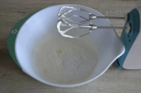 ふわふわの塊に冷たいクリームをホイップ 粉砂糖を追加します — ストック写真