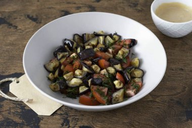 Dereotu, domates ve fırında patlıcanı derin bir kasede birleştirin. Karıştır.