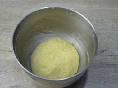 Hamuru ellerinle ya da mikserle yoğur. Hamur iyi yoğurulmalı, ellerle 7 dakika, mikserle 5 dakika kadar. Hamuru topa koyup, streç filmle kaplayıp 1,5 saat mayalamaya bırakın..