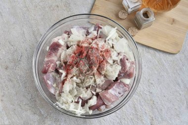 Ete kırmızı biber ve taze karabiber serpin, tatmak için tuz, ama cimrilik etmeyin. Soğan ve eti iyice yıka, biraz ovala ki soğan meyve suyu ve etle karışsın..