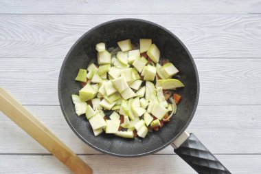 Kabağı yıka ve büyük ve eskiyse kabuğunu soy. Eğer genç olanın temizlenmeye ihtiyacı yoksa. Küçük parçalara böl ve tavaya ekle..