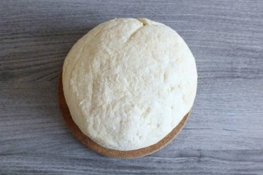 Yumuşak ve esnek bir hamur. Ellerine biraz yapışmalı. Yuvarla, havluyla sar ve 30 dakika masanın üzerinde bırak..