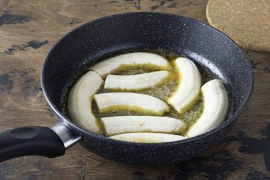 Şeker ve tereyağı eriyip açık kahverengiye döndüğünde muzları tavaya koy. Bir tarafta 1-2 dakika kızart..