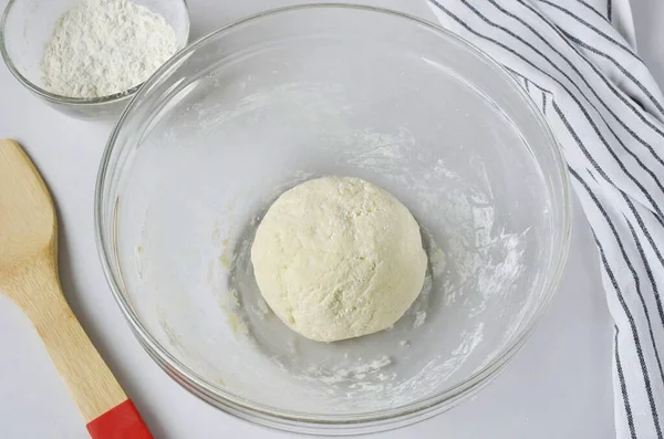 Önce hamuru çatalla karıştır, sonra da biraz tozlu bir masaya, yoğun bir çöreğe getir..