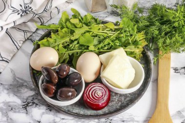 Arugula ve Halloumi Salatası yapmak için gerekli tüm malzemeleri hazırlayın. Yumurtaları 15 dakika önceden kaynatın ve buzlu suda soğutun. Kabuğundan soğanı soy ve durula..