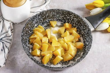 İki portakal soy ve orta küp doğra. Tavaya şeker dökün ve portakal dilimlerini koyun. Her şeyi 4-5 dakika kaynatın ve serinleyin..