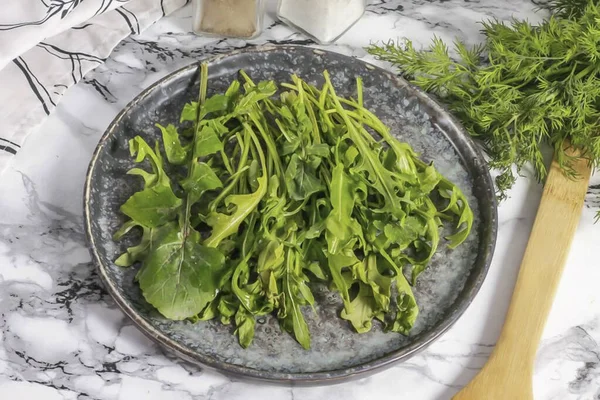 Rinse the arugula in water, cut off the stems and shake off excess moisture. Arrange the leaves on a plate.