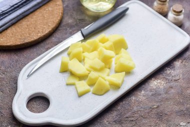 Patates soy, durula, kurula. Patatesleri küçük parçalara ayır..