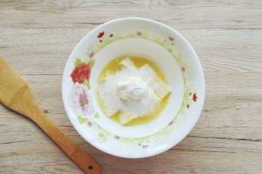 Ekşi krema ve kabartma tozu ekle. Bu malzemeleri karıştır.