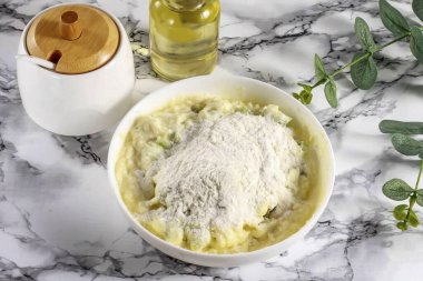 Buğday ununun yarısını dök ve kaymak tabakasına karıştır..